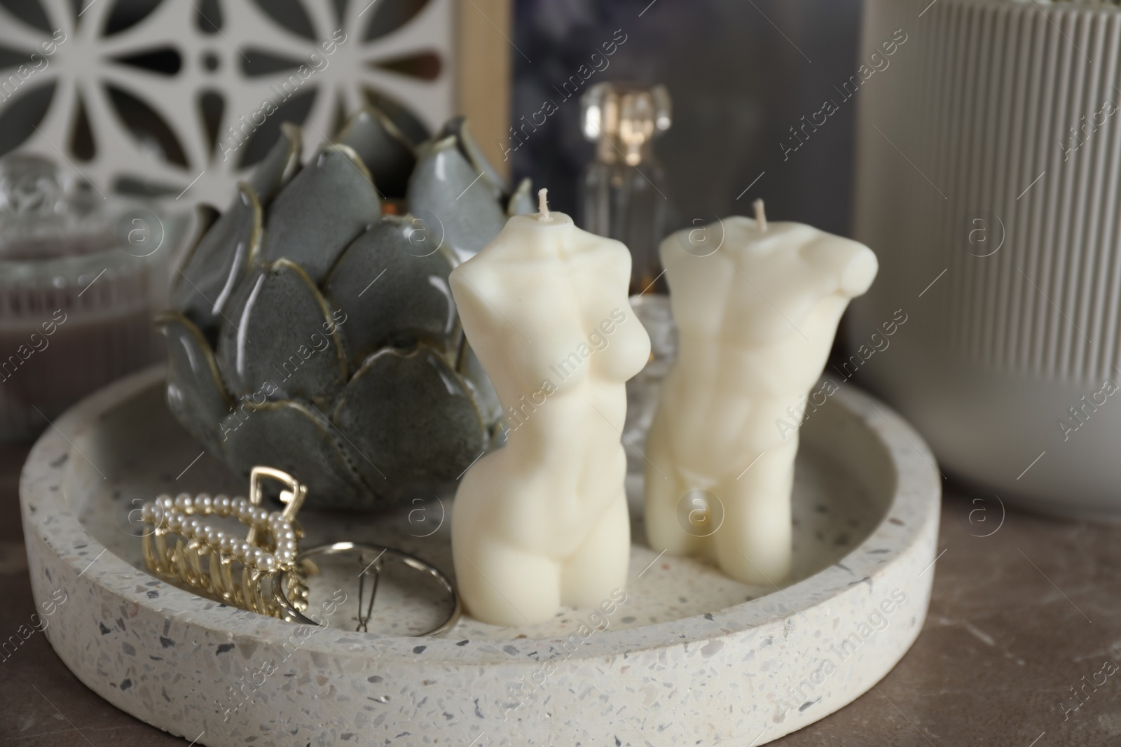 Photo of Beautiful male and female body shaped candles with decor on table