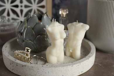 Beautiful male and female body shaped candles with decor on table