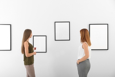 Photo of People viewing exposition in modern art gallery