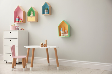 Photo of Children's room interior with house shaped shelves and little table