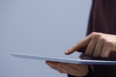 Photo of Closeup view of woman using modern tablet on grey background. Space for text