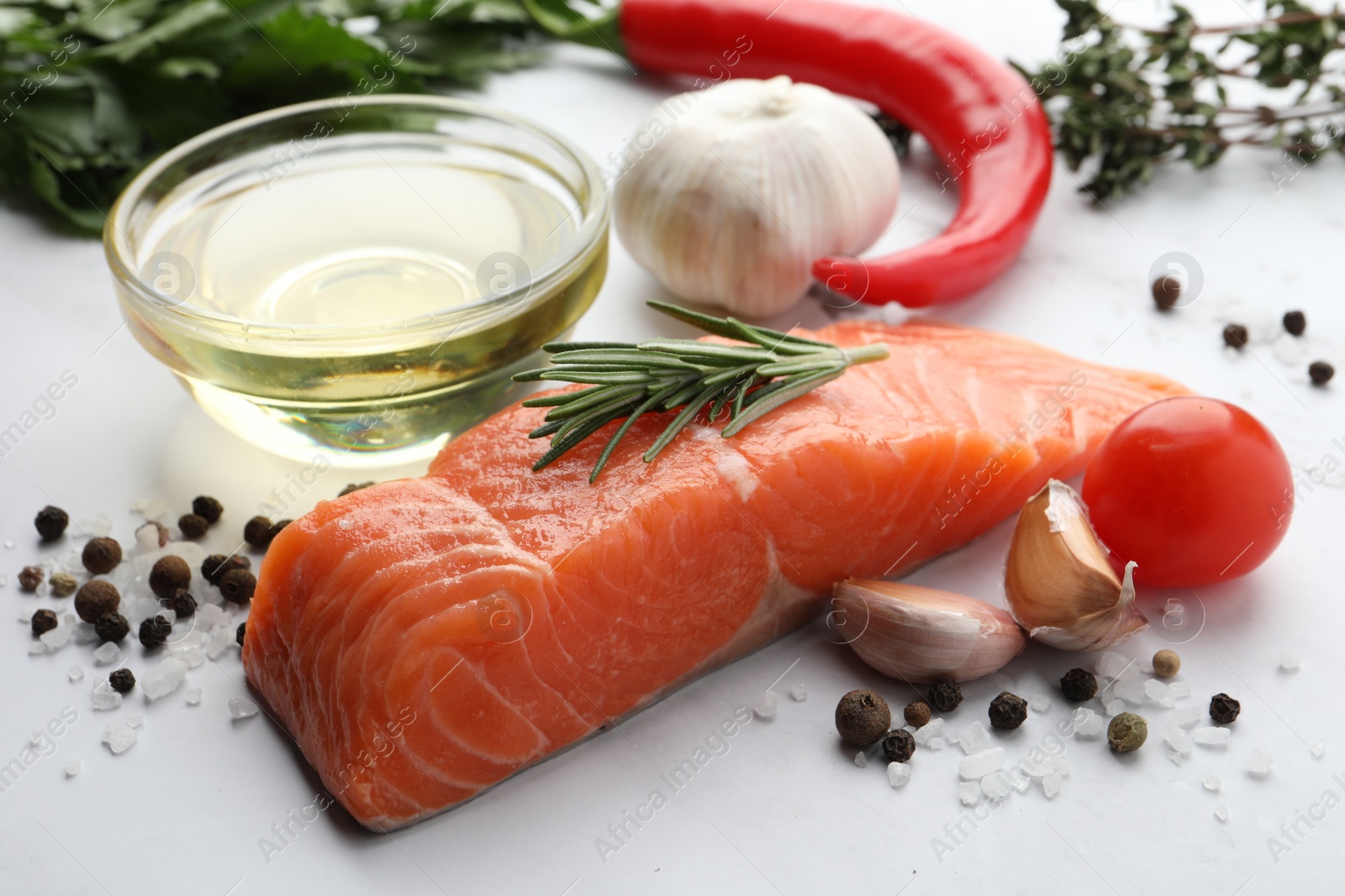 Photo of Fresh salmon and ingredients for marinade on white marble table, closeup