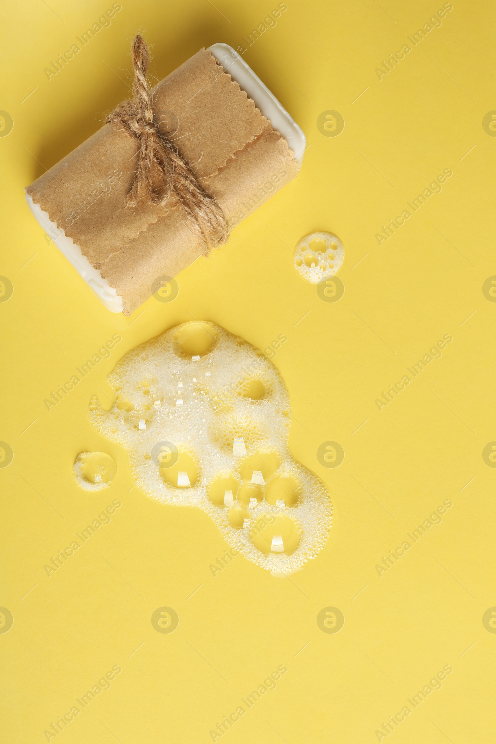 Photo of Craft soap bar and foam on color background, flat lay. Space for text