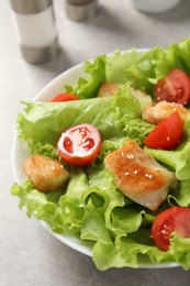 Delicious salad with chicken and cherry tomato on light grey table, closeup
