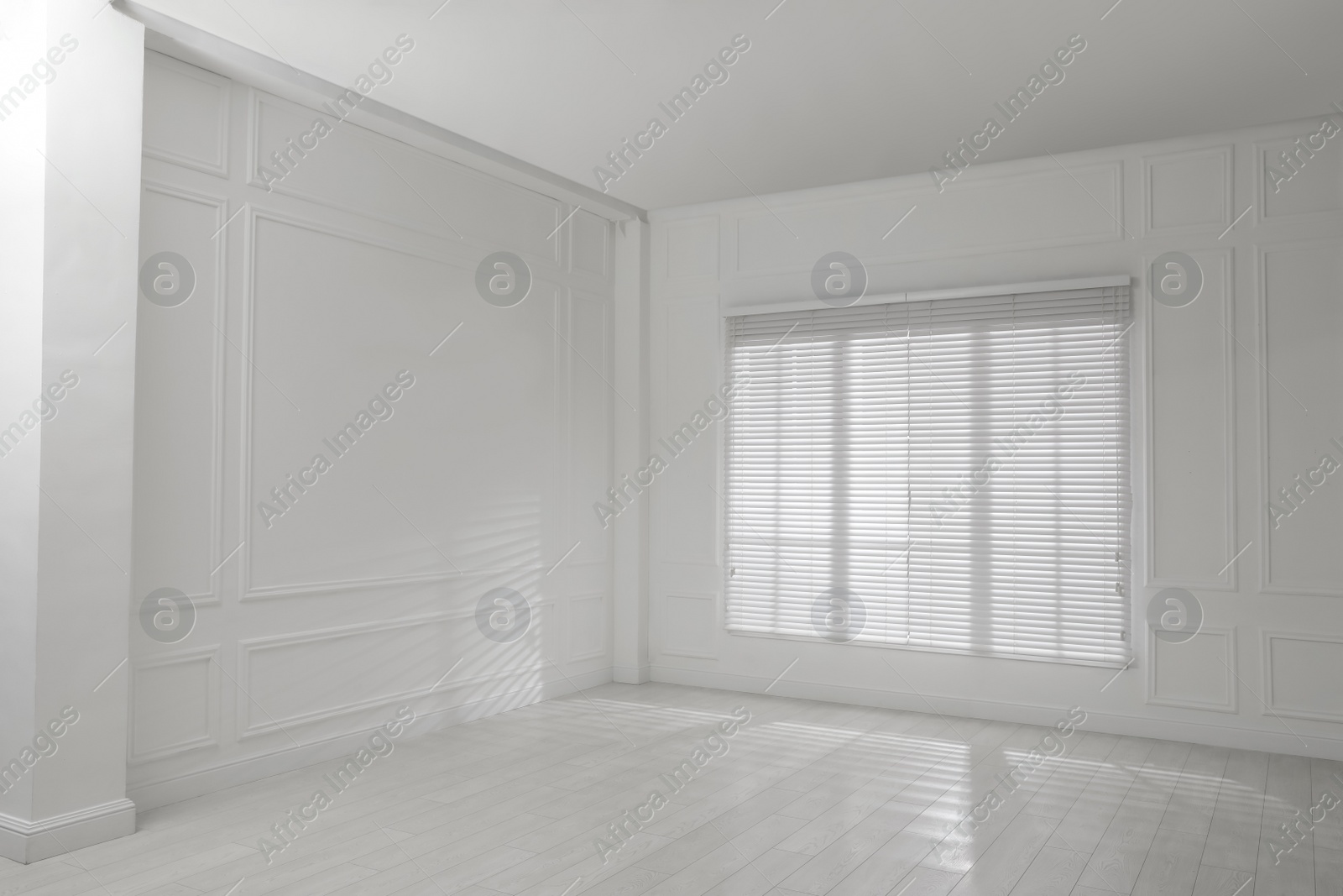 Photo of Empty room with white walls, large window and wooden floor