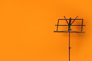 Photo of Empty music note stand on color background. Space for text