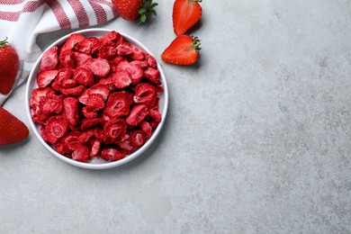 Photo of Freeze dried and fresh strawberries on light grey table, flat lay. Space for text
