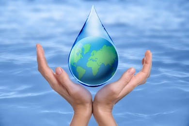 Image of Woman holding icon of Earth in drop on blue background, closeup. Water save concept