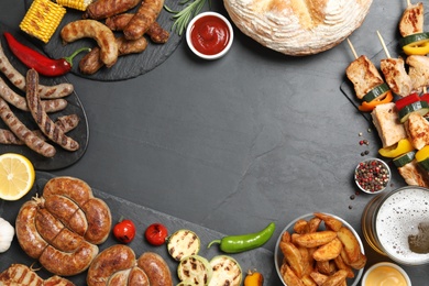 Photo of Frame of barbecued meat and vegetables on grey table, flat lay. Space for text