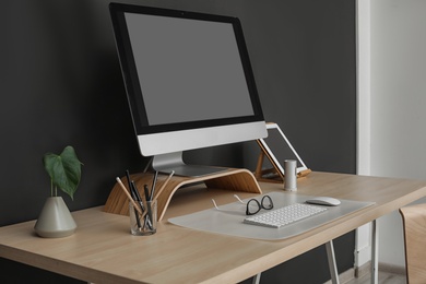 Photo of Modern workplace interior with computer on table. Space for text