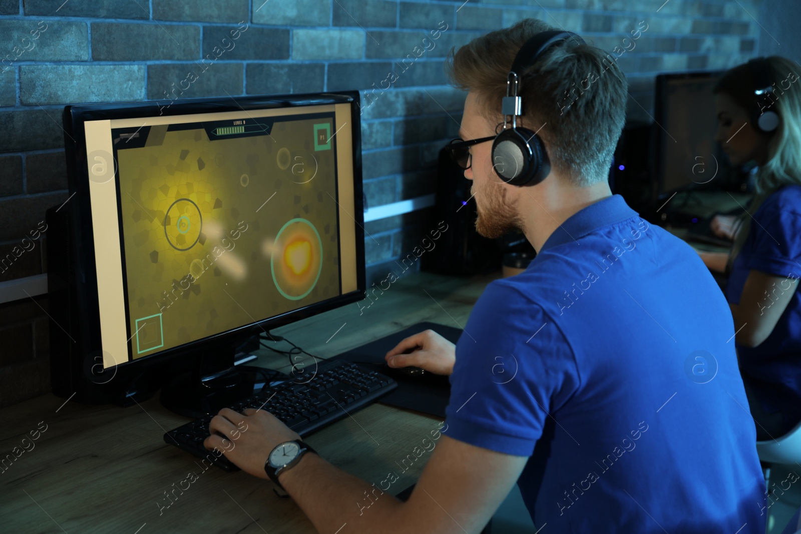 Photo of Man playing video game in internet cafe