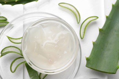 Aloe vera gel and slices of plant on white background, flat lay