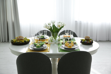 Photo of Festive Easter table setting with beautiful white tulips and eggs indoors