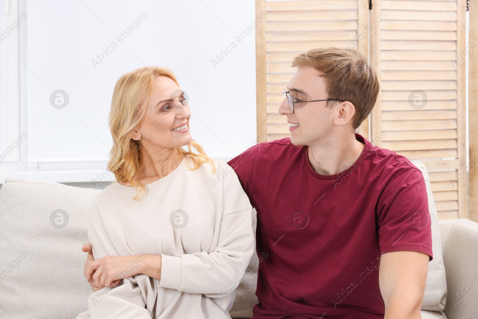 Photo of Mother and son spending time together on sofa at home. Family bonding