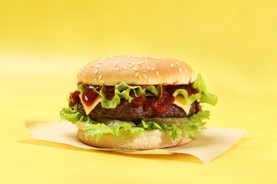 Photo of Burger with delicious patty on yellow background