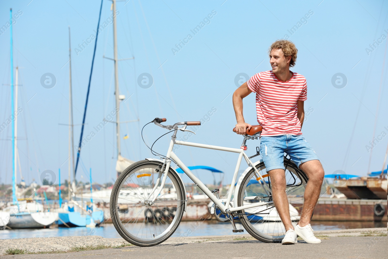 Photo of Handsome man with bicycle at pier on sunny day