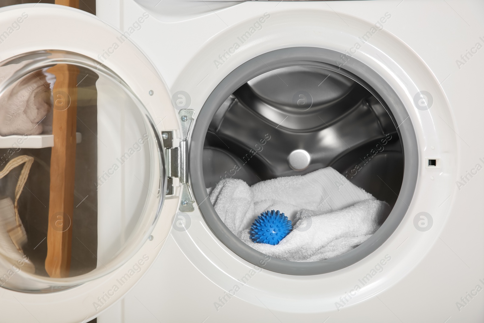 Photo of Blue dryer ball and towel in washing machine drum