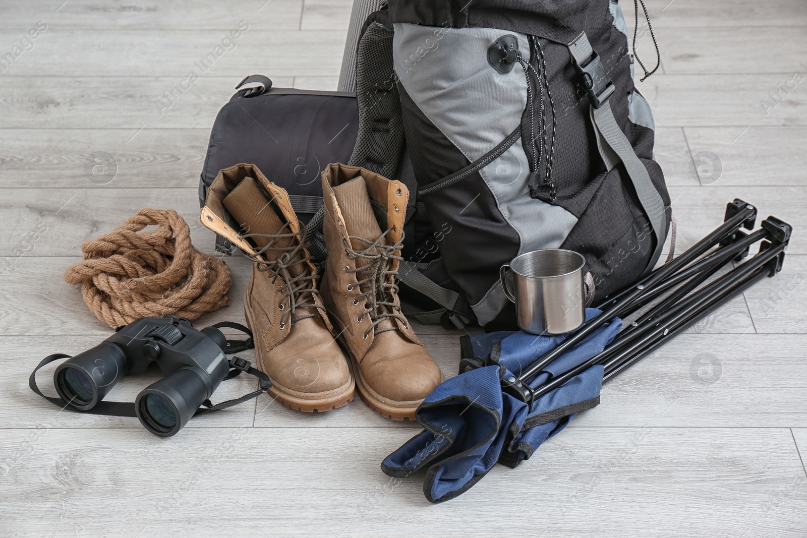 Photo of Set of camping equipment with sleeping bag on wooden floor