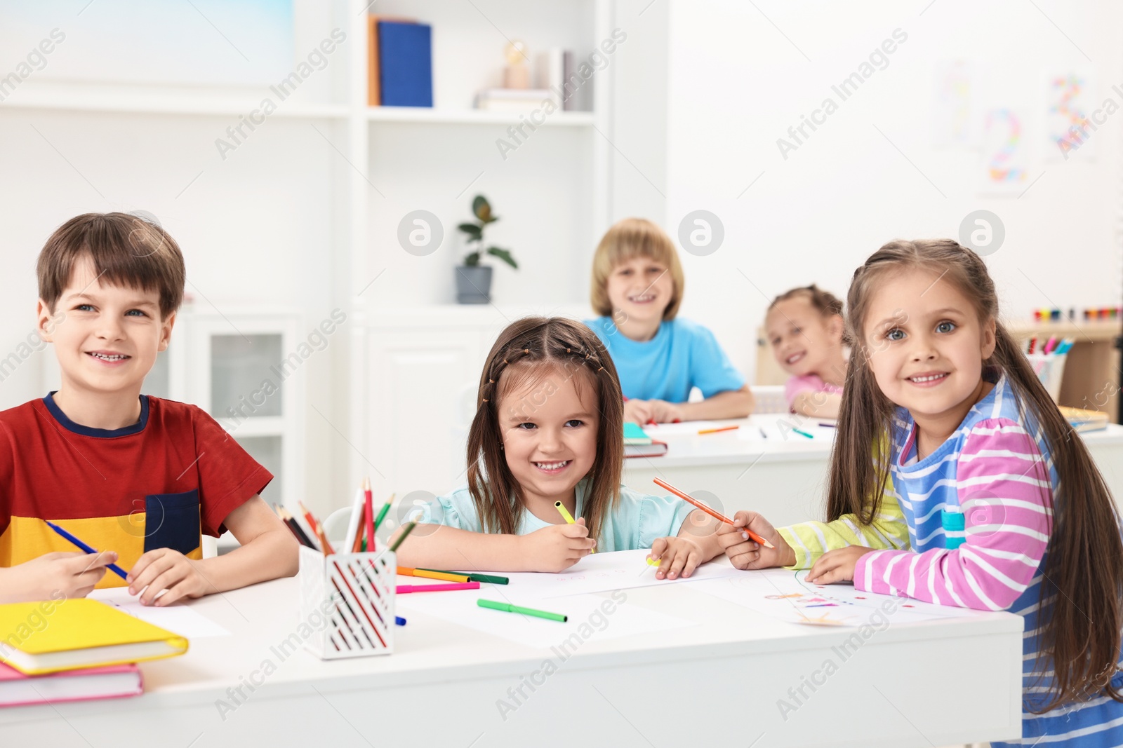 Photo of Group of children drawing at table indoors