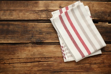 Photo of Striped kitchen towels on wooden table, top view. Space for text