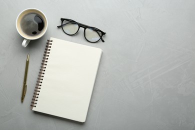 Flat lay composition with open notebook on light textured table. Space for text