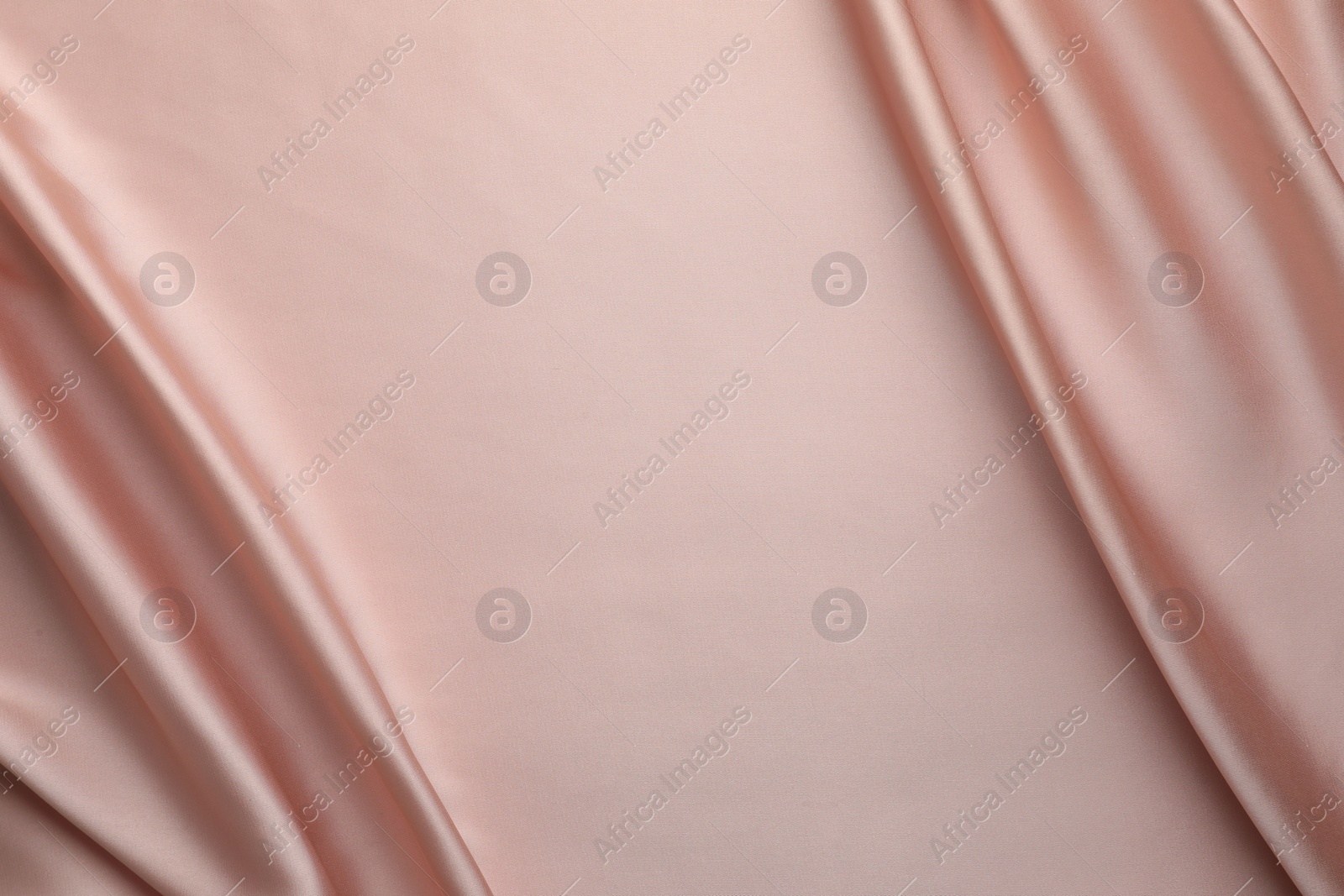 Photo of Crumpled pink silk fabric as background, top view. Space for text