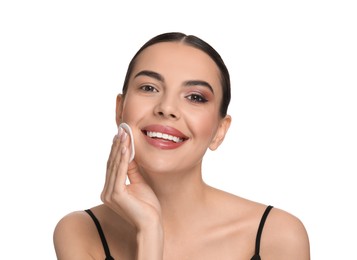 Photo of Beautiful woman removing makeup with cotton pad on white background