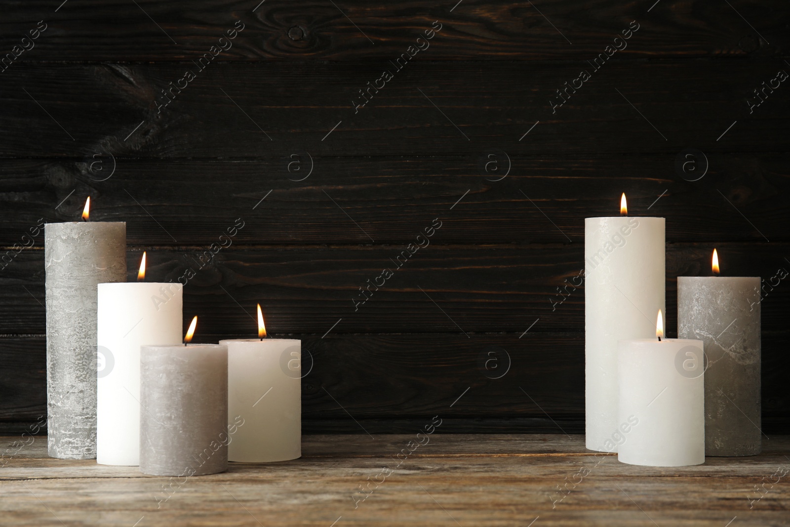 Photo of Alight wax candles on table. Space for text