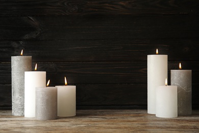 Photo of Alight wax candles on table. Space for text