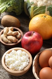 Photo of Healthy meal. Different vegetables and raw eggs on wooden table, closeup