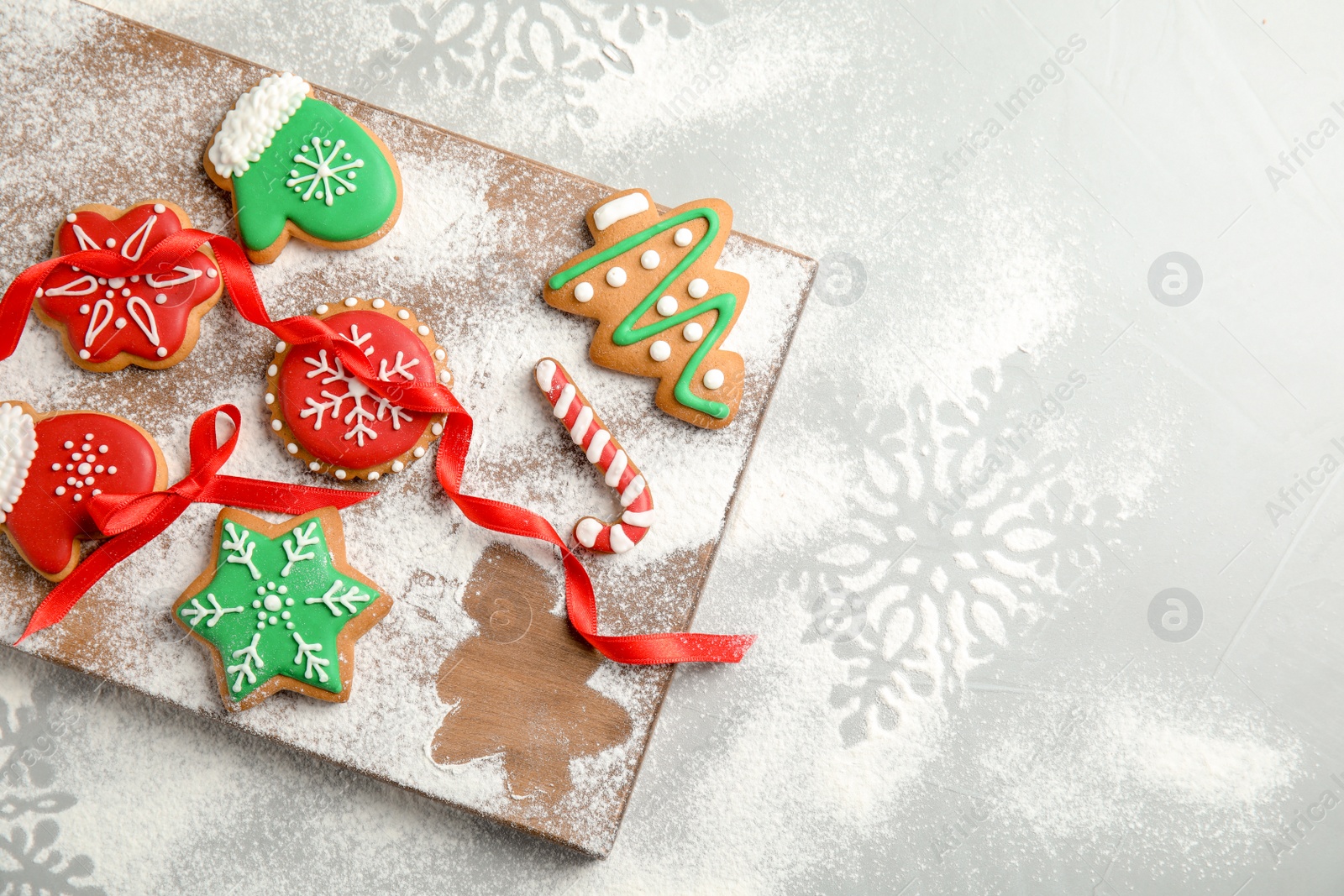 Photo of Tasty decorated Christmas cookies on wooden board, top view