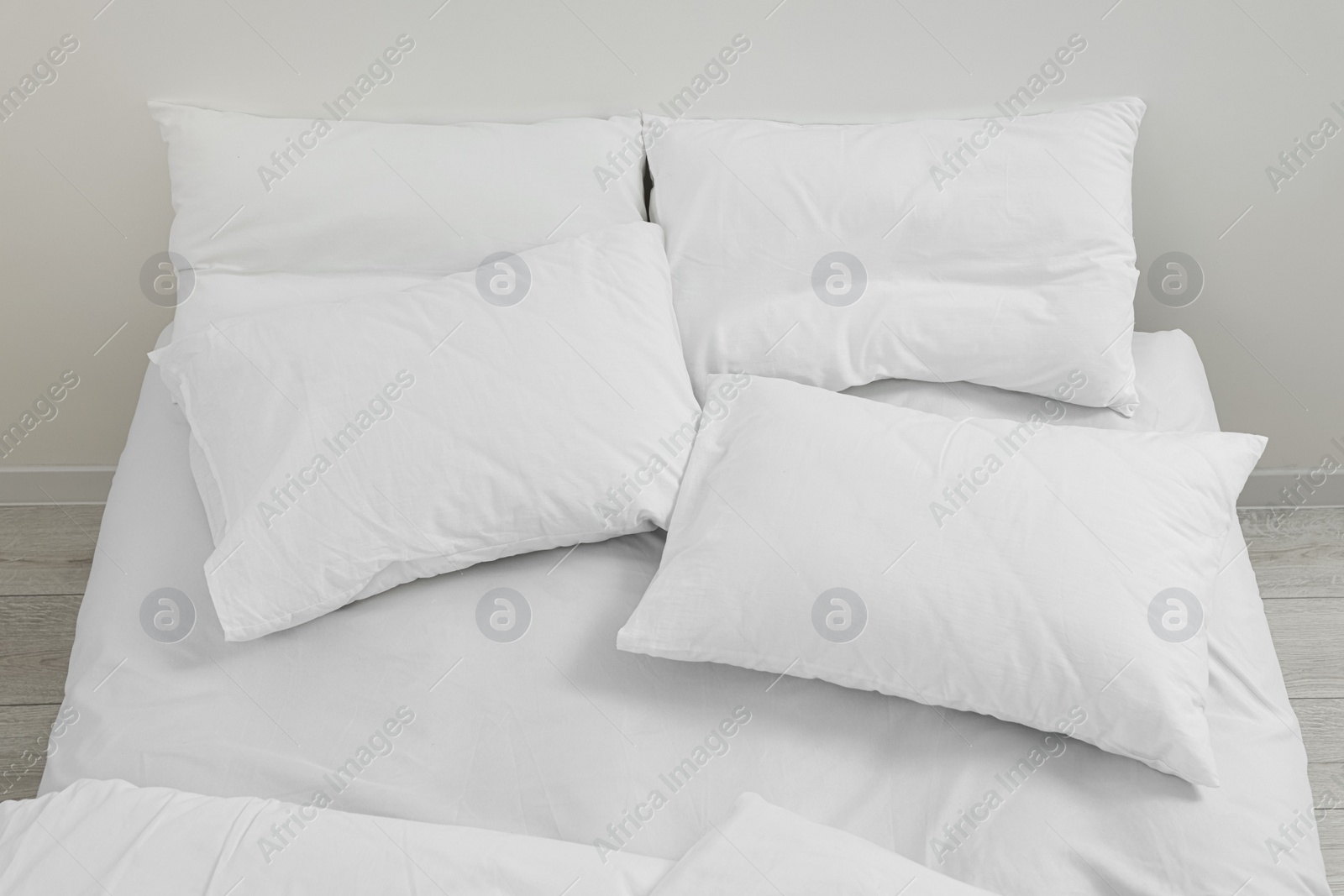 Photo of White soft pillows on cozy bed in room