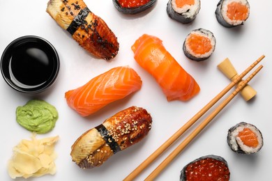 Photo of Set of delicious sushi rolls on white background, flat lay