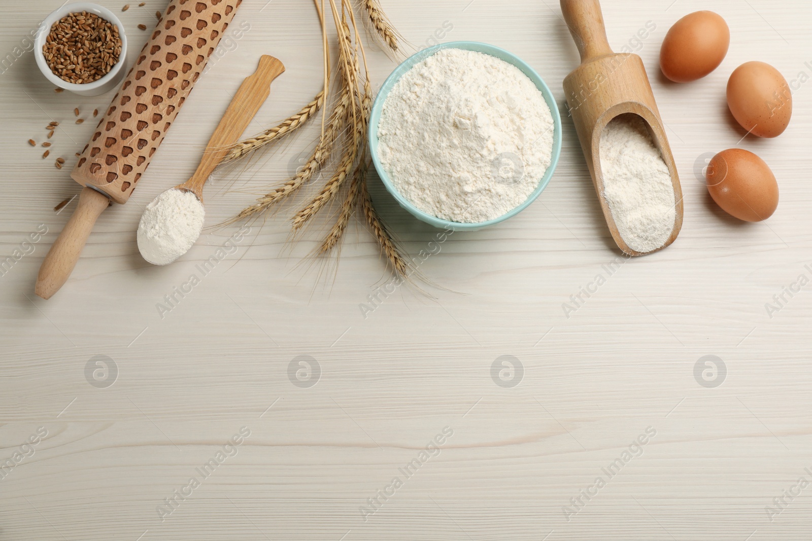 Photo of Flat lay composition with wheat flour and eggs on white wooden table. Space for text