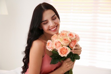Photo of Young woman with beautiful bouquet at home