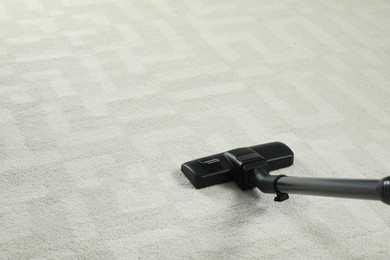 Removing dirt from white carpet with modern vacuum cleaner. Space for text
