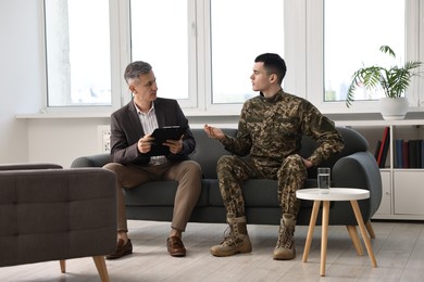 Professional psychotherapist working with military man in office