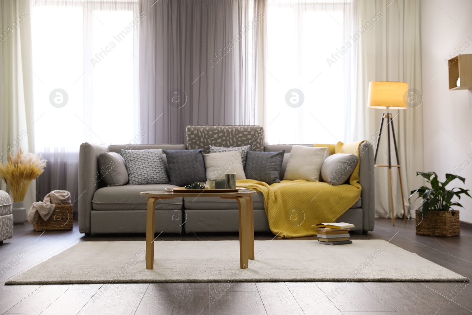 Photo of Elegant living room with comfortable sofa near windows. Interior design