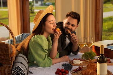 Romantic date. Beautiful couple having picnic in wooden gazebo