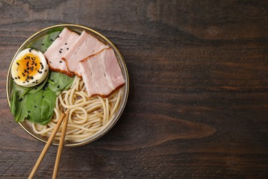 Photo of Delicious ramen with meat on wooden table, top view and space for text. Noodle soup