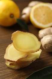 Photo of Cut ginger and lemon on wooden table, closeup