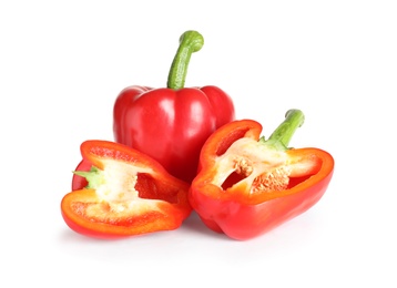 Cut and whole ripe red bell peppers on white background