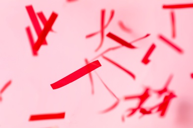 Photo of Shiny red confetti falling down on pink background