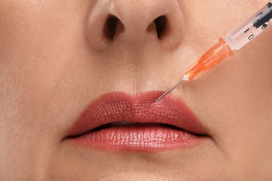 Photo of Senior woman getting lips injection, closeup. Cosmetic surgery