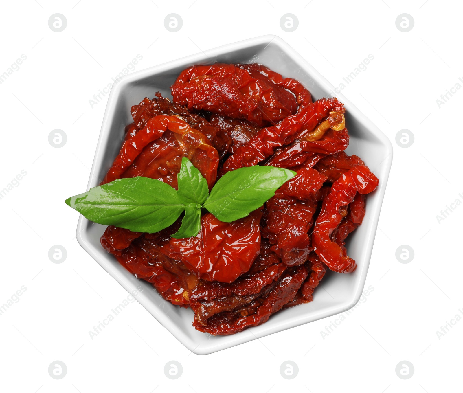 Photo of Bowl with sun dried tomatoes and green leaves on white background, top view