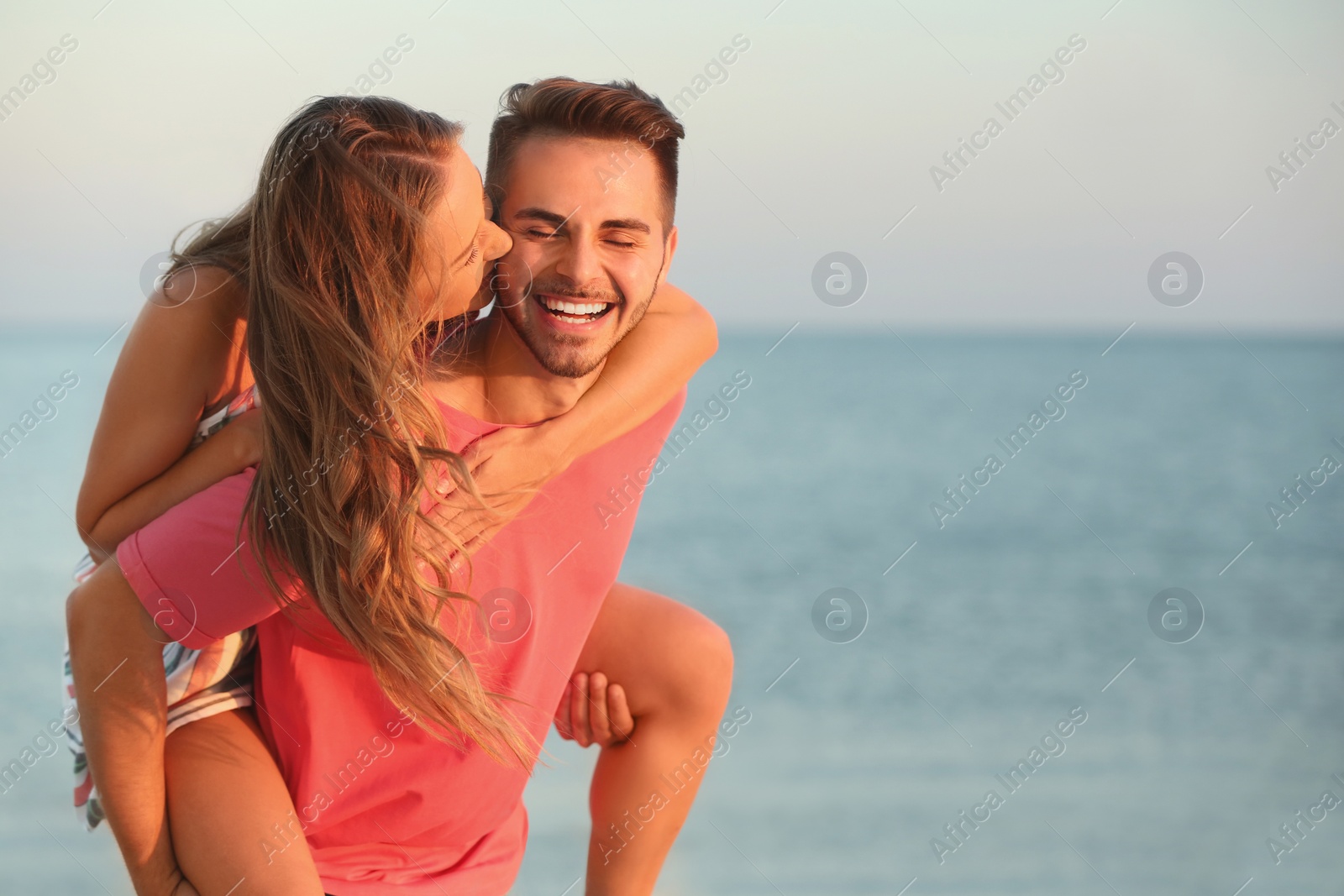 Photo of Happy young couple playing together on beach