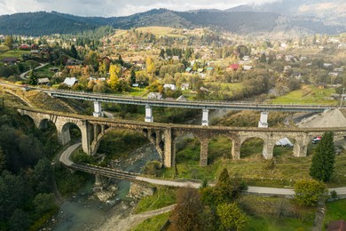 Image of Aerial view of bridges and village on autumn day