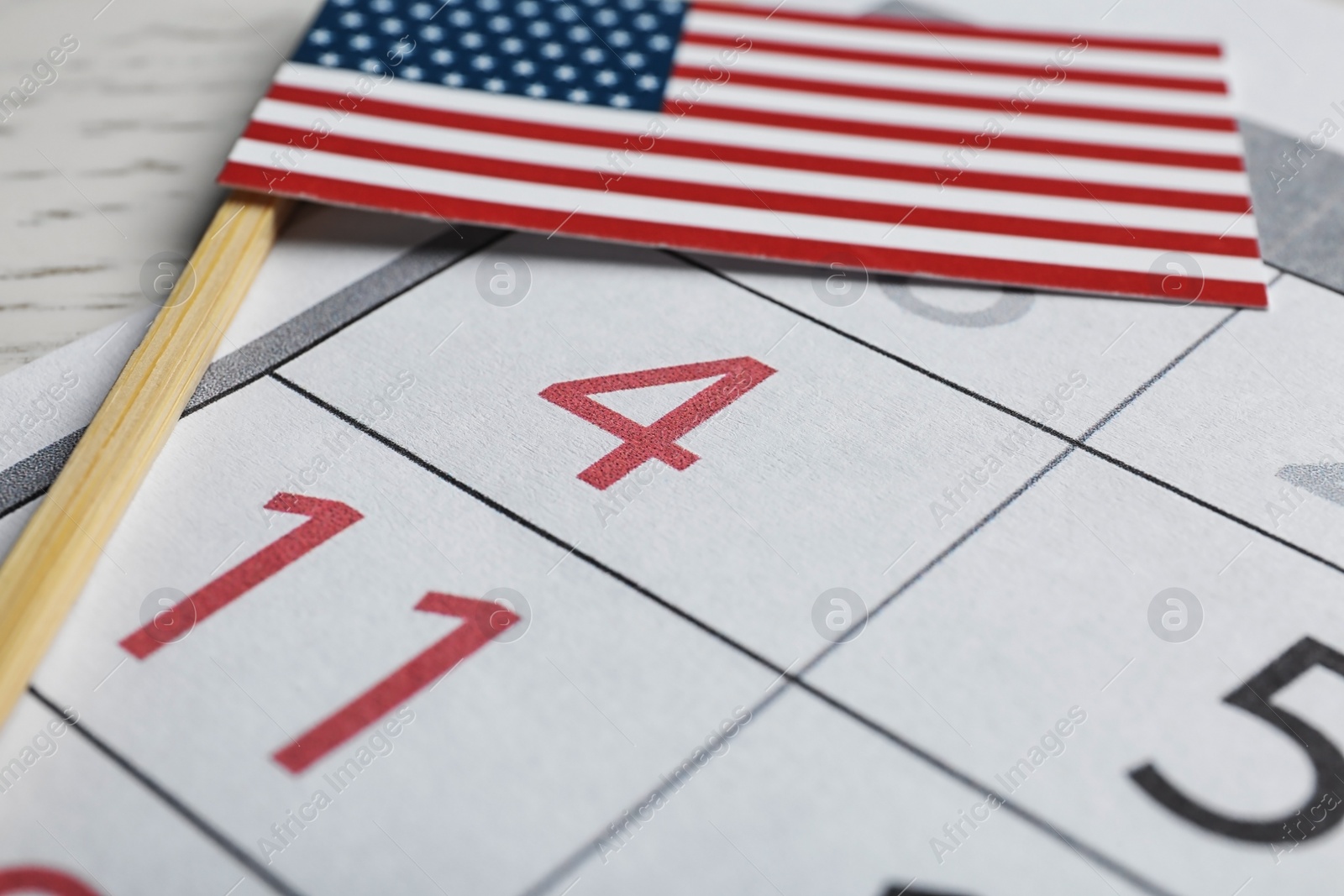 Photo of Composition with USA flag and calendar on  table, closeup. Happy Independence Day