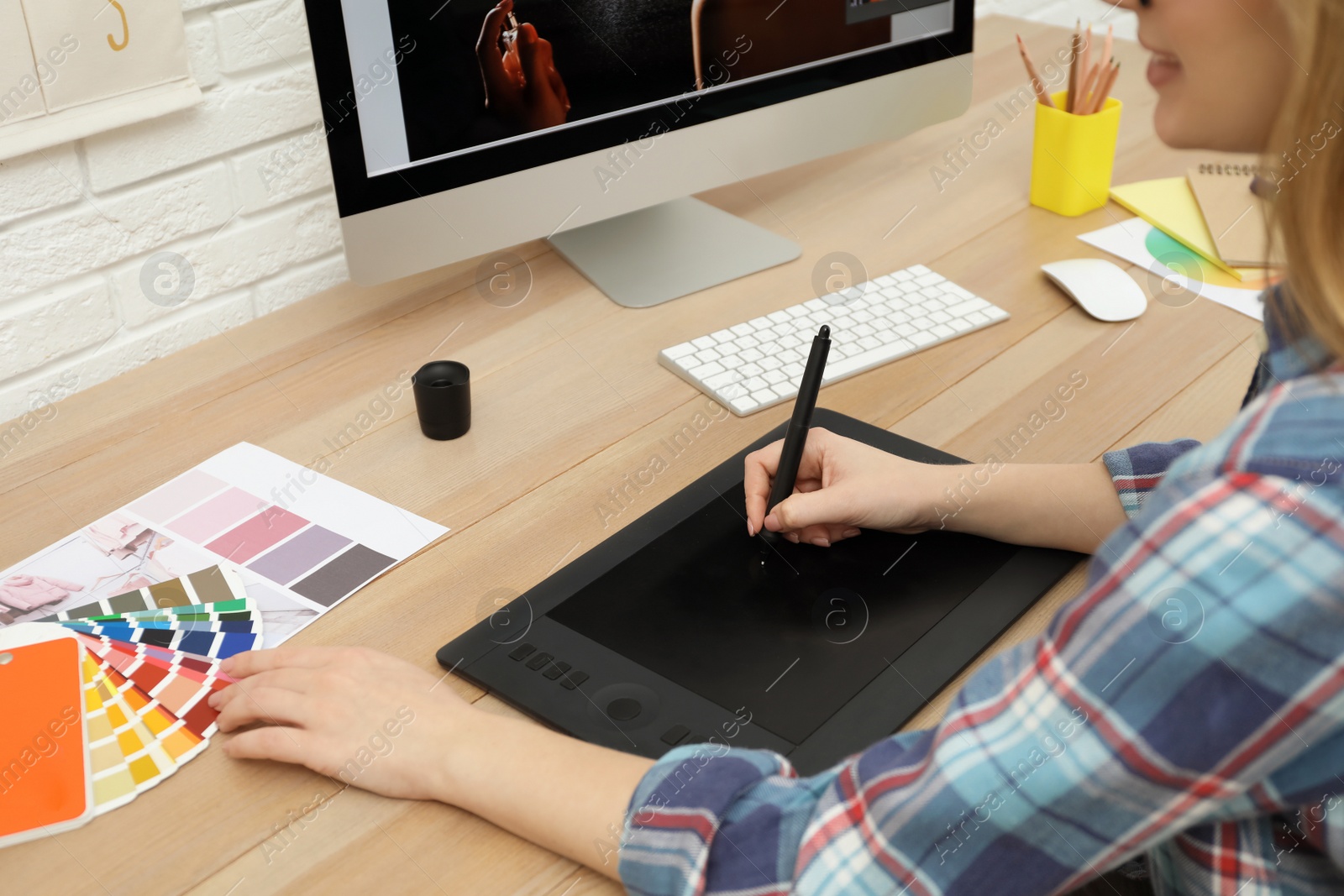 Photo of Professional retoucher working on graphic tablet at desk, closeup