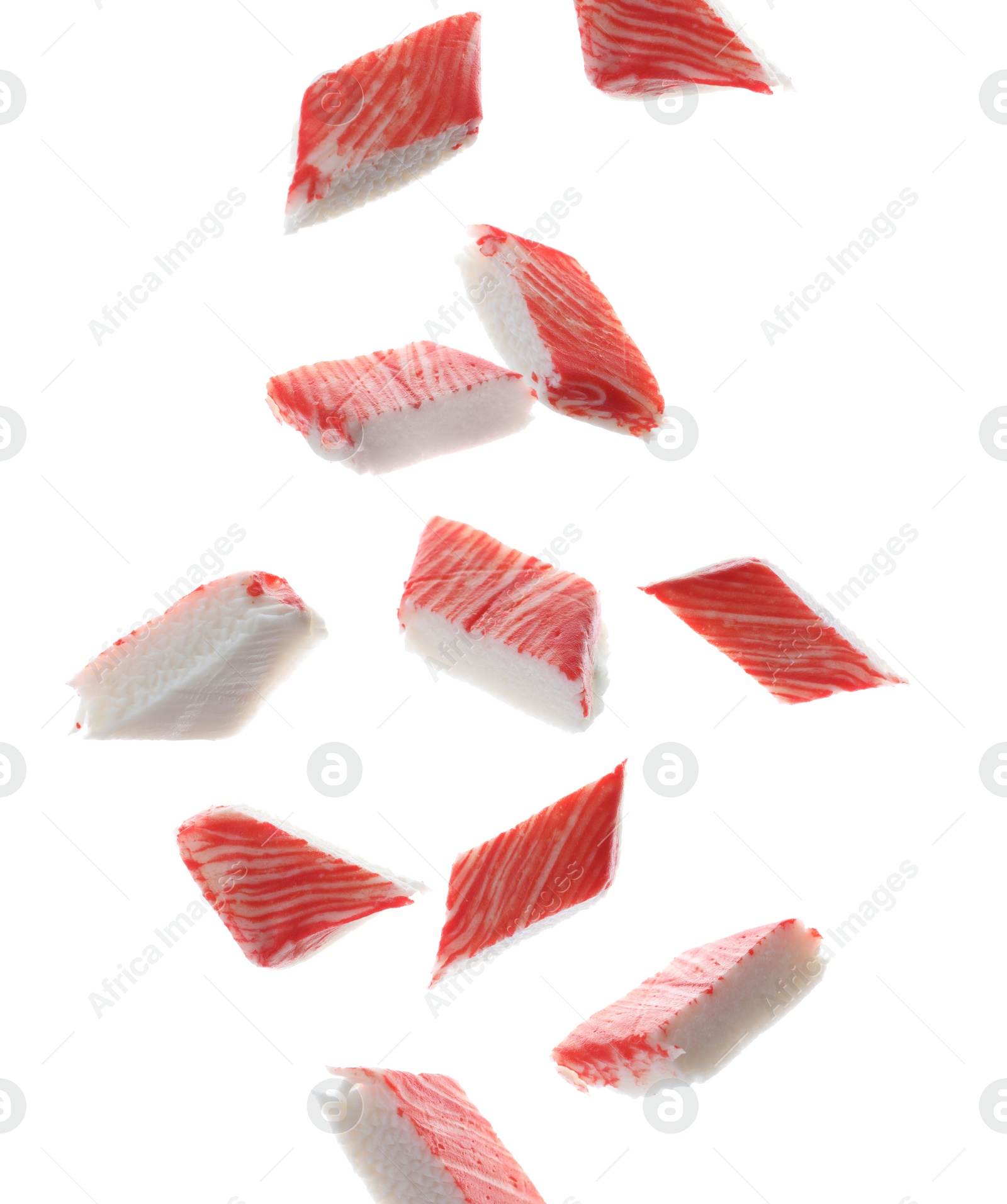 Image of Cut fresh crab sticks falling on white background